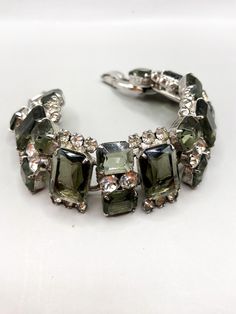 Vintage Juliana Art Deco Smoky Gray Glass Bracelet with Clear Rhinestones 1960-s. Elegant and beautiful, in great vintage condition. No missing or dark stones, no chips on glass. 7 8/16 x 1 inches measurements Vintage Jeweled Metal Crystal Bracelet, Vintage Rhinestone Bracelets For Evening, Art Deco Multi-stone Collectible Jewelry, Vintage Multicolor Rhinestone Jewelry, Luxury Antique Multi-stone Bracelets, Grey Glass, Glass Bracelet, Clear Rhinestones, Chain Link Bracelet