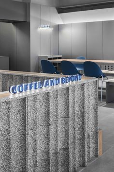 the coffee and beyond sign is displayed in front of an office cubicle with blue chairs