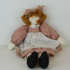 a stuffed animal is sitting on a white surface and wearing a pink dress with black shoes