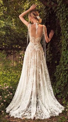 the back of a woman's wedding dress, with her hands on her head