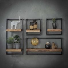 three wooden shelves with plants and vases on them against a gray wall in a room