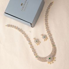 Description: This marvelous CZ long necklace set by Tarinika is as timeless as it is radiant. Both necklace and earrings display a beautiful arrangement of high-quality CZ stones, glittering brilliantly in the form of florals. Perfect to accentuate wedding outfits with an elegant touch, this necklace set can be combined with matching pieces of Tarinika CZ jewelry for a grand loyal look. Details & Specifications: Materials used: CZ Stone with White Gold Plating Weight - Necklace 74.75 gms, Earrin Elegant Bridal Earrings With Stone Work In Cubic Zirconia, Festive Cubic Zirconia Jewelry Sets For Wedding, Festive Wedding Jewelry Sets With Cubic Zirconia, Festive Formal Crystal Jewelry Sets, Cubic Zirconia Jewelry Sets With Stone Work For Wedding, Elegant Diamond Bridal Earrings With Stone Work, Wedding Jewelry Sets With Cubic Zirconia Stone Work, Elegant Bridal Sets With Crystal Stone Work, Elegant Festive Crystal Jewelry Sets