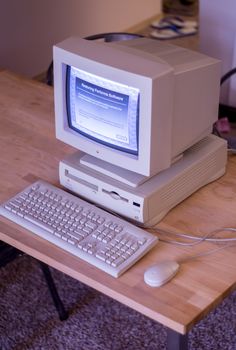 an old computer sitting on top of a wooden desk next to a keyboard and mouse