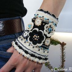 a close up of a person's hand wearing a bracelet with flowers on it