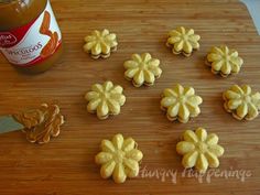 some cookies are sitting on a cutting board next to a jar of peanut butter