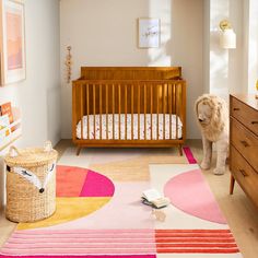 a baby's room with a crib, dresser and rug in the foreground