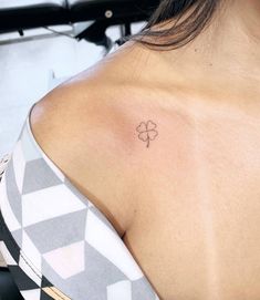 a woman with a small clover tattoo on her shoulder