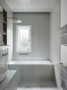 a bath room with a tub a sink and a window