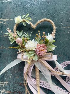 a heart shaped basket with flowers and ribbons