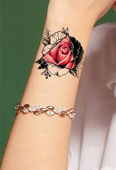 a woman's arm with a rose tattoo on it and a chain around the wrist