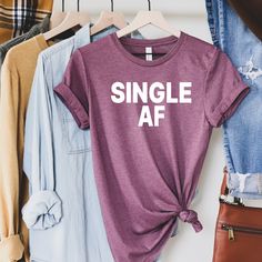 "Single AF Shirt - Single Shirt - Single As - Valentine Shirt - Hate Love Shirt - Custom Shirts - Sarcastic shirts - Single and shirt - gift Single AF THIS LISTING IS FOR ONE SHIRT 1. Chose size and color of shirt - add to cart 2. Go back choose more sizes/colors as needed If you have any questions, feel free to ask. Adult Unisex Triblend short sleeved Crew Neck. 50% Poly 25% Combed Ring-Spun Cotton 25% Rayon This shirt is Unisex so for a female, it is a little loose - if you like them \"FORM FI Hate Love, Single Af, Single Shirt, Valentine Shirt, Sarcastic Shirts, Love Shirt, Valentines Shirt, Cool Shirts, Custom Shirts