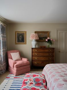 a bedroom with a bed, chair and dresser