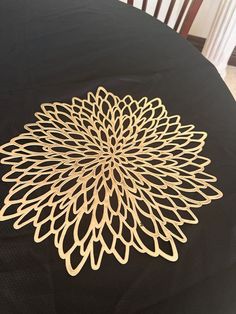 a wooden cutout of a flower sitting on top of a black cloth covered table