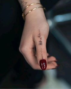 a woman's hand with a small tattoo on it