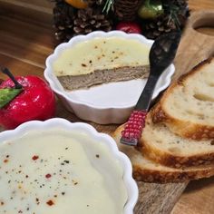 three bowls with food in them sitting on a wooden table next to some fruit and bread