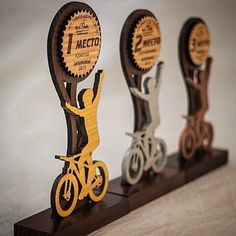 three wooden trophies with bicycles on them