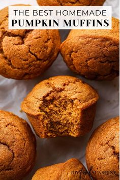 several muffins on a white surface with one cut in half to show the inside