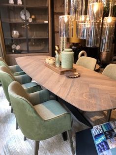 a dining room table surrounded by chairs and vases