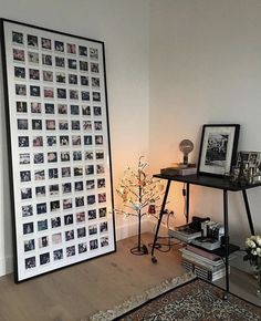 a living room filled with furniture and pictures on the wall next to a table topped with flowers