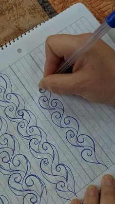 someone is doing something with their hand on the paper that has been made into an intricate pattern