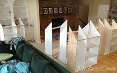 a living room filled with furniture and a fire place next to a wall mounted book shelf