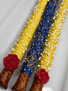 three corn on the cob decorated with red, white and blue flowers sitting on top of each other