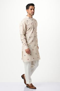 Beige kurta with paisley and floral printed motifs, front buttons and mandarin neck. Paired with pyjama.
Components: 2
Pattern: Printed
Type Of Work: Paisley,Floral
Neckline: Mandarin
Sleeve Type: Full Sleeves
Fabric: Silk, Cotton
Color: Beige
Other Details: 
Weight approx: 400 grams
Model height: 6ft, wearing size M
Occasion: Mehendi and Puja - Aza Fashions Long Sleeve Kurta With Kalamkari Print For Weddings, Long Sleeve Kalamkari Print Kurta For Wedding, Traditional Kurta With Paisley Print For Festivals, Traditional Paisley Print Kurta For Festivals, Festive Straight Kurta With Paisley Print, Traditional Paisley Print Kurta For Festive Occasions, Traditional Festive Kurta With Paisley Print, Festive Paisley Print Straight Kurta, Festive Paisley Print Kurta