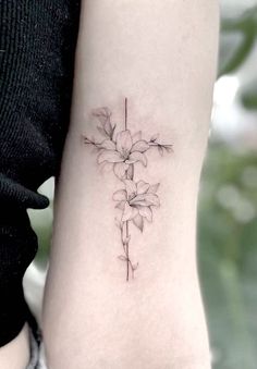 a cross tattoo with flowers on the arm