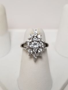 "Thanks for shopping our vintage estate store. We tend to sell well below wholesale and truly hope you enjoy all of our items. Many of the items are one of a kind, so please enjoy scrolling through the pictures and hopefully something will catch your eye. Brown spots are from camera or reflections. Beautiful estate 10k white gold 1ct CZ diamond waterfall cocktail ring. Sweet ring, one that you will love. Gems are testing natural, so they might be bright white topaz or iolite. Ring size: 4 Setting: 3/4\" by 3/8\" Band width: 2mm Weight: 3.52 grams There are 24 cz diamonds that are approx. 1ct tw. Marked 10k." Cluster Ring With Vs Clarity Cubic Zirconia, Vintage Diamond Cluster Ring With Vs Clarity, Classic Cluster Cubic Zirconia Jewelry, Classic Hallmarked Cluster Ring With Cubic Zirconia, Vintage Cubic Zirconia Cluster Ring With Halo Setting, Vintage Silver Cluster Ring With Cubic Zirconia, Hallmarked Cluster Ring With Cubic Zirconia Round Cut, Vintage Cluster Cubic Zirconia Rings, Vintage Cubic Zirconia Jewelry With Halo Setting