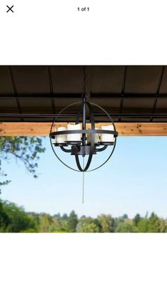 a chandelier hanging from the ceiling in front of an outdoor dining table and chairs