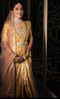 a woman in a gold sari posing for the camera