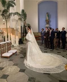 the bride is walking down the aisle in her wedding dress