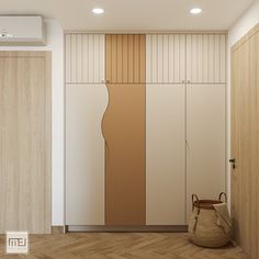 an empty room with wooden flooring and white cupboards on the wall next to a basket