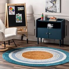 a child's room with a blue rug and white rocking chair