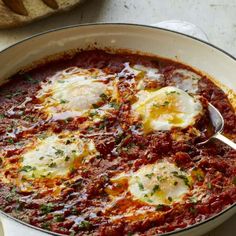 an egg dish is shown in a white bowl with bread on the side, and it's ready to be eaten