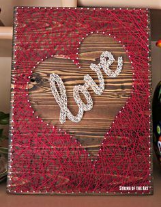 string art on wood with the word love spelled out in white and red yarn next to a bottle opener