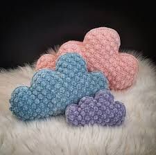 three crocheted hearts sitting on top of a white fur covered floor next to each other