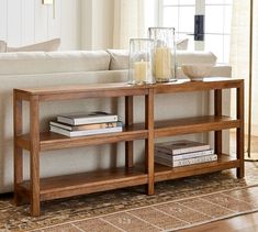 a living room with a couch, coffee table and books on the shelf next to it