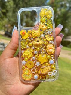 a person holding up a phone case with yellow and orange buttons on it's side