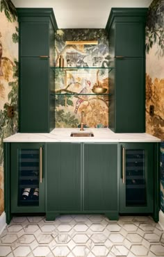 a kitchen with green cabinetry and wallpaper on the walls, along with a marble counter top