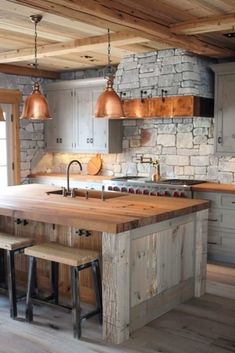 a kitchen with an island made out of wooden planks and two stools in front of it