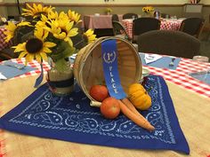 sunflowers, tomatoes and carrots in a bucket on a table at a restaurant