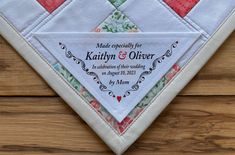 a quilted wedding gift hanging on a wooden wall with the words made especially for kathy and olver