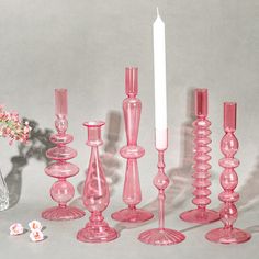 pink glass candlesticks are lined up next to each other