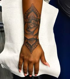 a woman's arm with a rose tattoo on her left hand and an eye in the middle