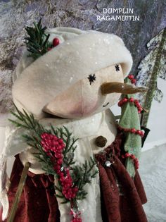 a stuffed animal wearing a red and white dress with holly wreaths on it's head