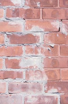 a brick wall that has been painted red and white with some paint chipping on it