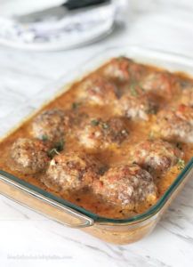 a casserole dish filled with meatballs and sauce