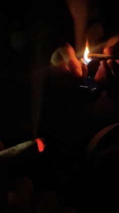 a person holding a lit lighter in their hand