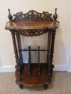 an old wooden table with two vases on it's shelf next to a wall